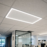 A modern rectangular LED ceiling light panel installed in a white acoustic tile office ceiling, with a glass-walled meeting room visible in the background.