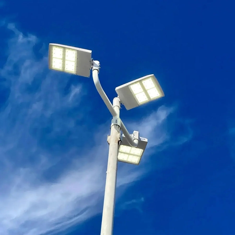 White LED parking lot lights mounted on a multi-arm pole providing wide-area illumination for commercial parking facilities.