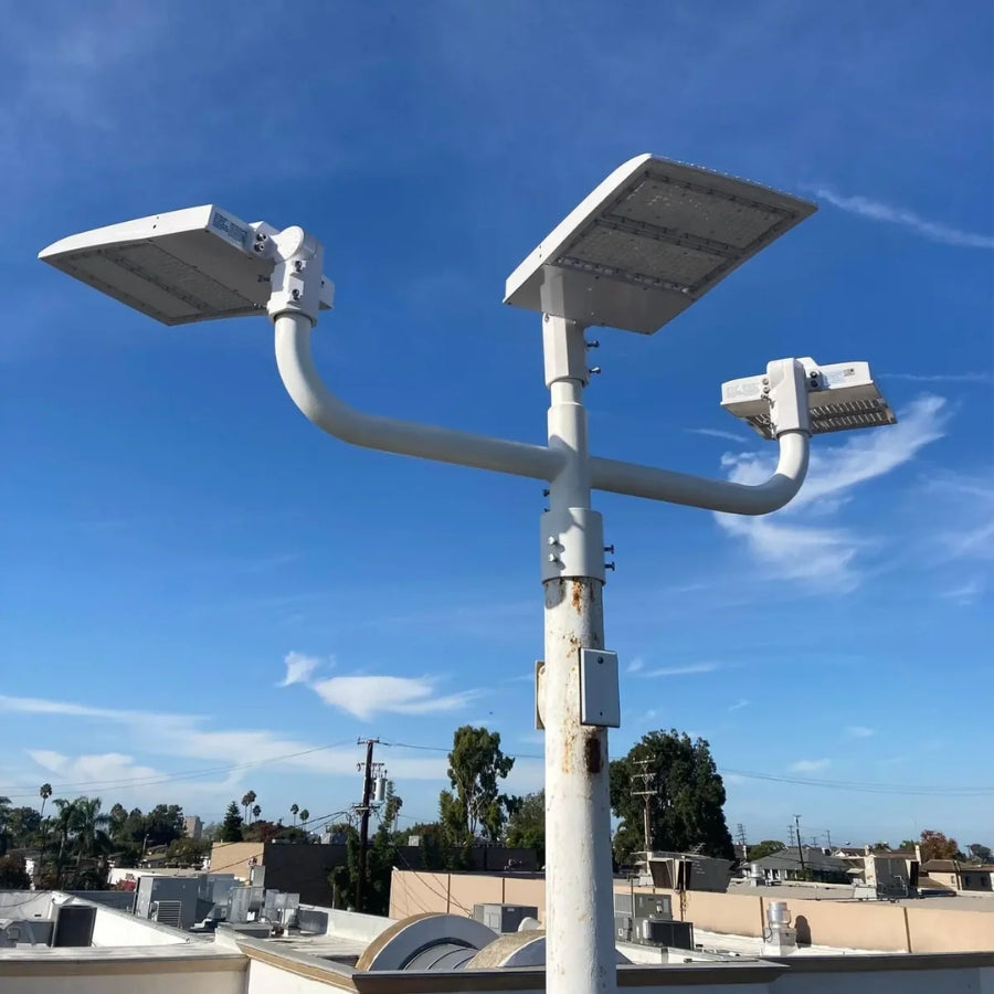 White LED area lighting fixtures mounted on a commercial light pole in a real-world outdoor installation environment.