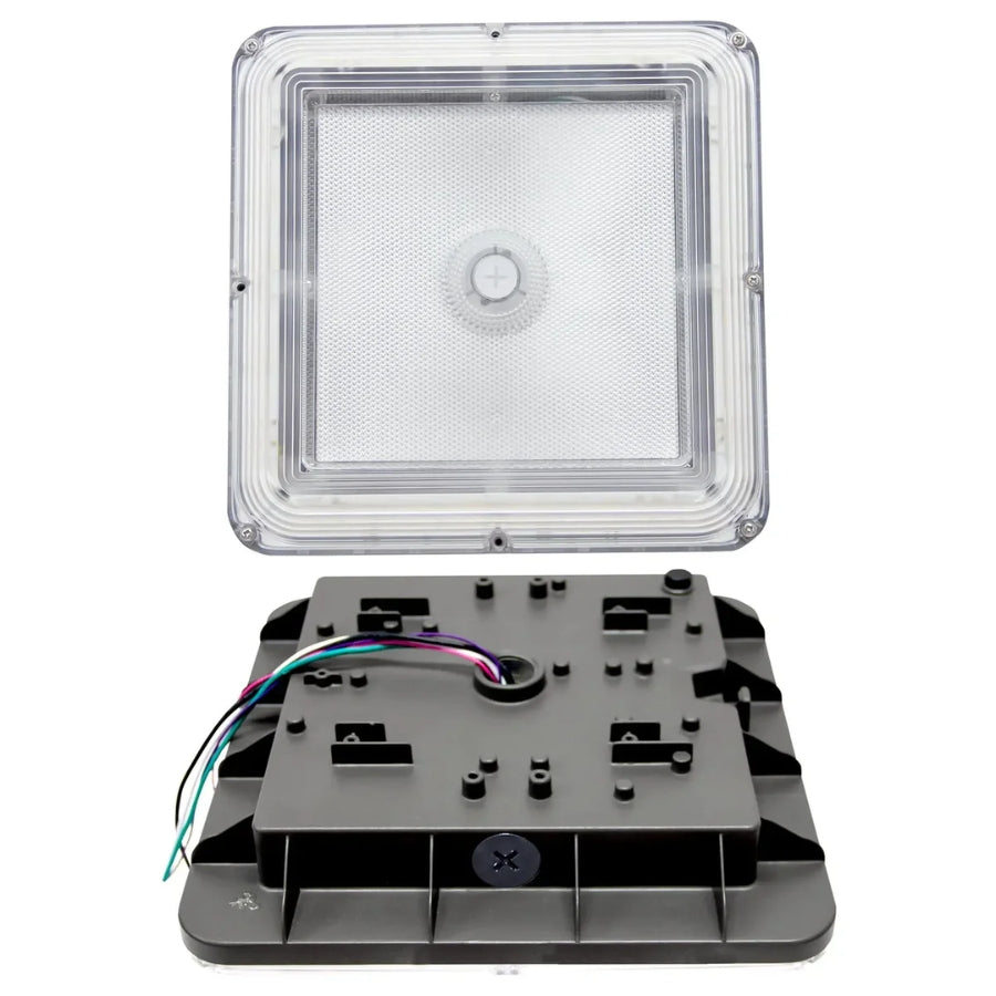 A square outdoor light fixture shown disassembled with the clear textured lens cover removed and set above the black plastic mounting base, which features a multicolor wire harness.