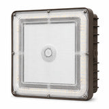 A square industrial LED light fixture with a clear protective lens, showing the internal LED strip and a brown metal housing with side heat fins.